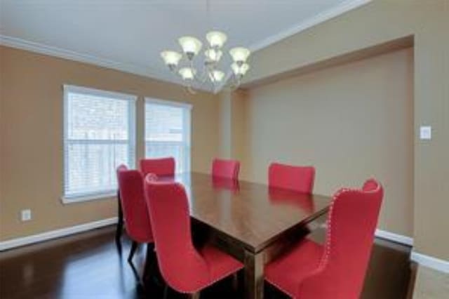 dining room with crown molding, dark wood-type flooring, and a chandelier