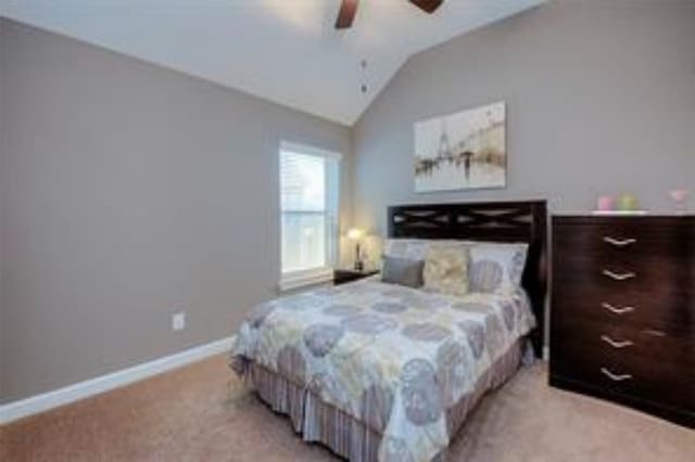 bedroom with lofted ceiling, ceiling fan, and light colored carpet