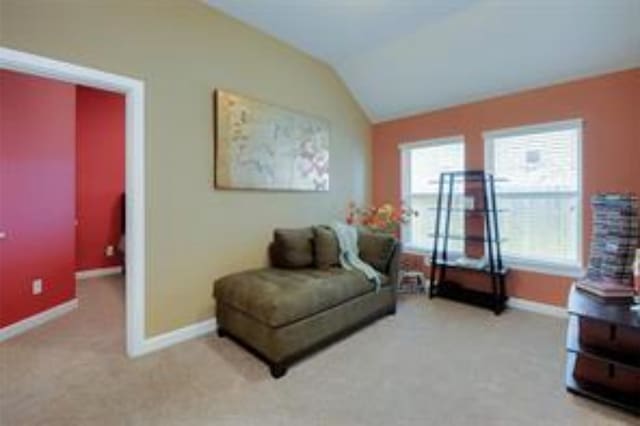 living area with light carpet and lofted ceiling