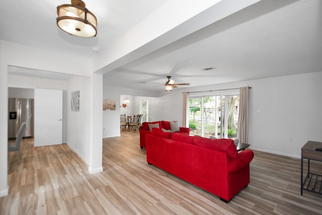 living room featuring light wood-type flooring and ceiling fan