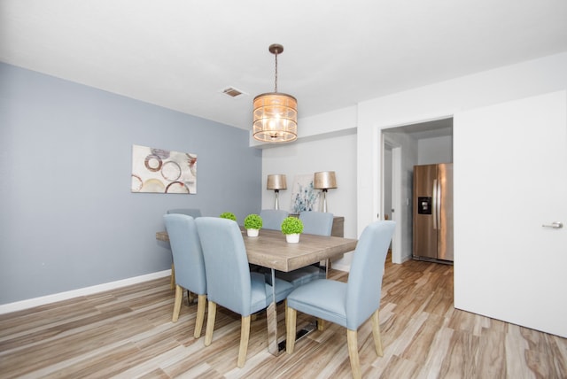 dining area with a chandelier and light hardwood / wood-style floors