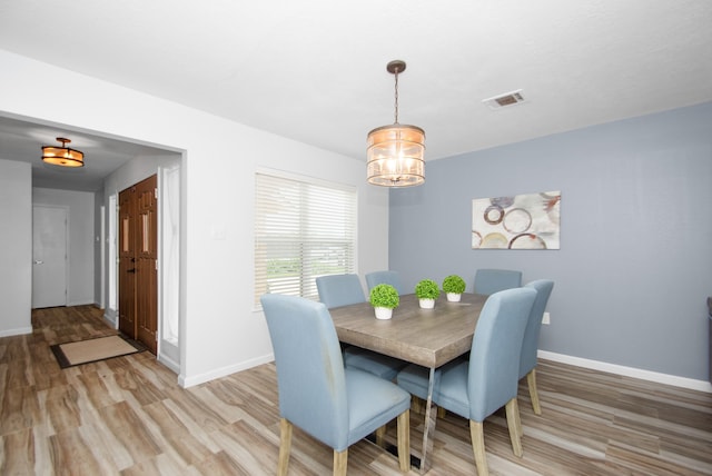 dining room featuring a notable chandelier and light wood-type flooring