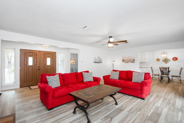 living room with light hardwood / wood-style floors and ceiling fan