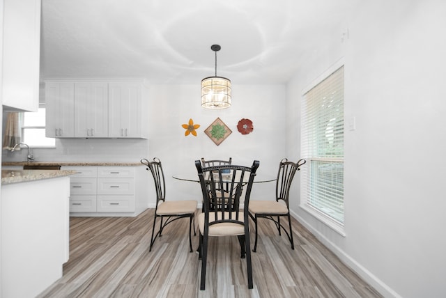 dining room featuring a notable chandelier, light hardwood / wood-style floors, and a healthy amount of sunlight