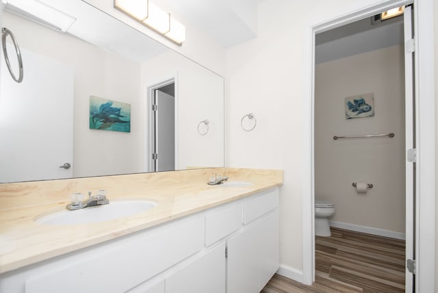 bathroom with vanity, toilet, and hardwood / wood-style flooring