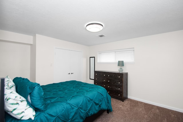 bedroom featuring a textured ceiling and carpet flooring