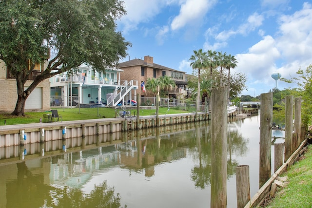 view of dock with a water view and a yard