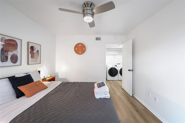 bedroom featuring independent washer and dryer, ceiling fan, and light hardwood / wood-style flooring