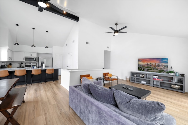 living room with high vaulted ceiling, beam ceiling, light hardwood / wood-style floors, and ceiling fan