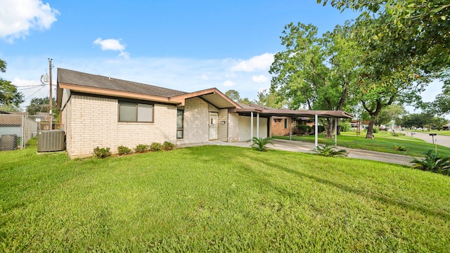 ranch-style house featuring a front lawn and central AC unit