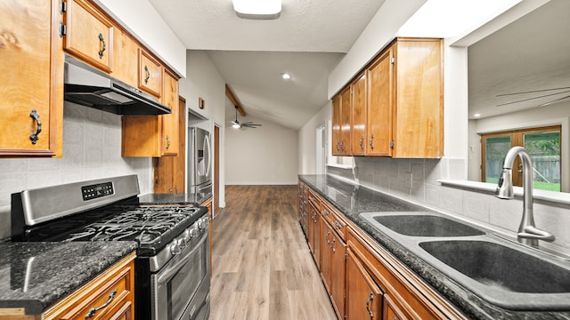 kitchen with lofted ceiling, sink, tasteful backsplash, appliances with stainless steel finishes, and light wood-type flooring