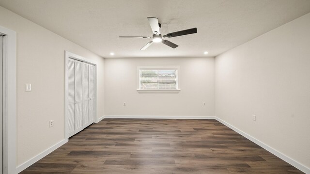 unfurnished bedroom with a closet, ceiling fan, and dark wood-type flooring