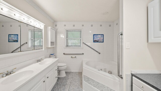 bathroom with tile walls, a tub to relax in, vanity, tile patterned flooring, and toilet