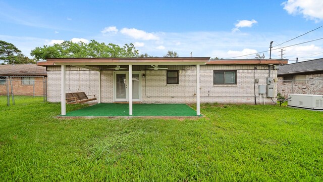 back of house with a lawn, ceiling fan, and a patio