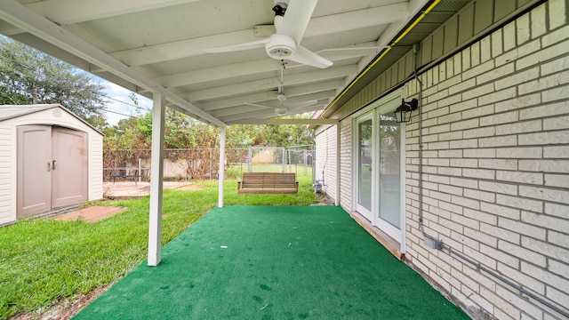 view of patio with ceiling fan and a storage unit