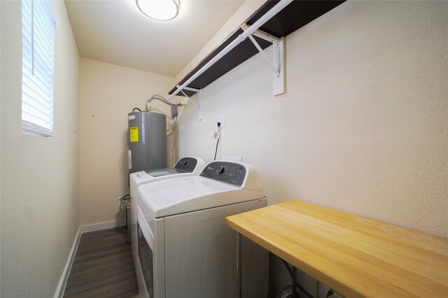 washroom featuring water heater, separate washer and dryer, dark hardwood / wood-style flooring, and a wealth of natural light