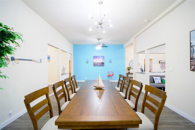 dining room featuring ceiling fan with notable chandelier and dark hardwood / wood-style flooring