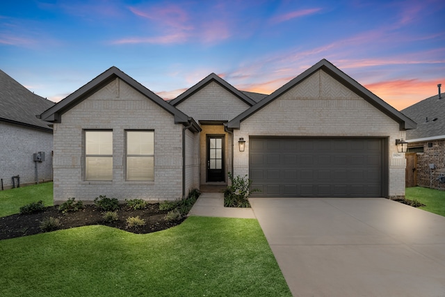 view of front of home featuring a garage and a yard