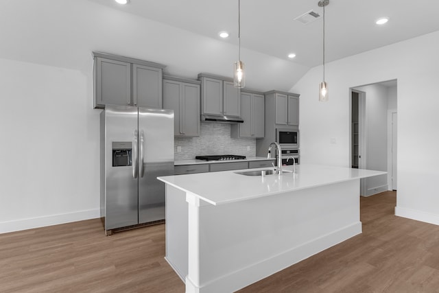 kitchen featuring light hardwood / wood-style floors, stainless steel appliances, sink, and vaulted ceiling