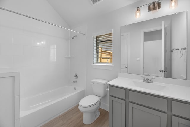 full bathroom featuring vanity, hardwood / wood-style floors, vaulted ceiling, toilet, and tiled shower / bath