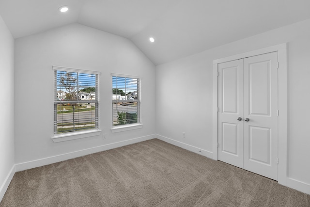 spare room with vaulted ceiling and carpet floors