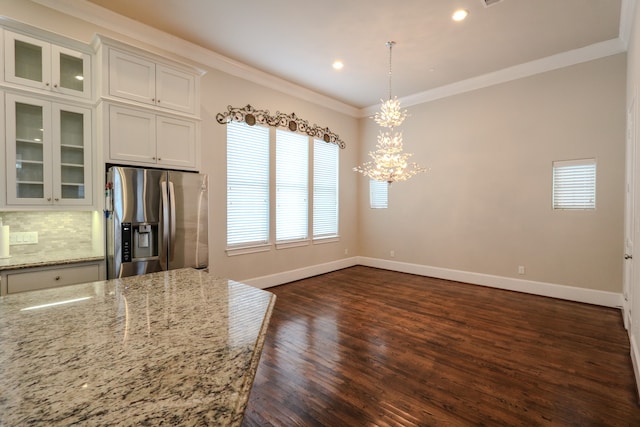 kitchen featuring light stone counters, dark hardwood / wood-style floors, white cabinets, stainless steel refrigerator with ice dispenser, and decorative light fixtures