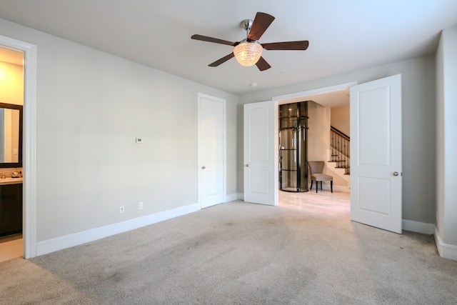 unfurnished bedroom with connected bathroom, ceiling fan, and light colored carpet