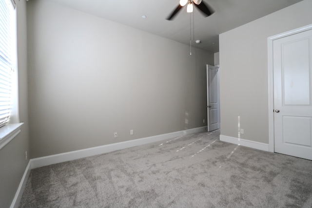 unfurnished bedroom featuring multiple windows, light carpet, and ceiling fan