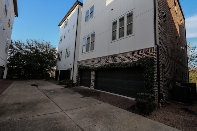 exterior space with a garage and central AC