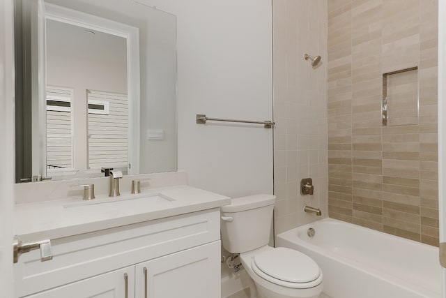 full bathroom featuring vanity, toilet, and tiled shower / bath