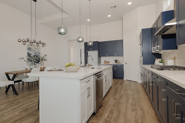 kitchen featuring white cabinetry, sink, pendant lighting, and hardwood / wood-style flooring