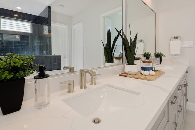 bathroom featuring vanity and tiled shower