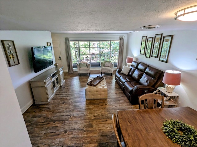 living room featuring a textured ceiling and dark hardwood / wood-style flooring