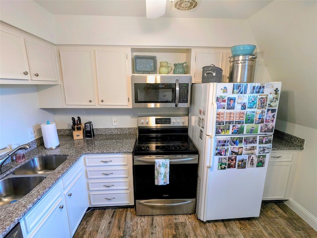 kitchen with sink, dark wood-type flooring, white cabinetry, stainless steel appliances, and dark stone countertops