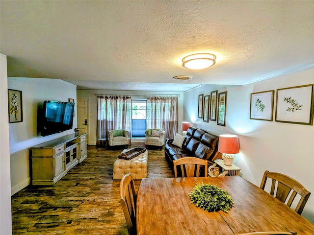 dining area with a textured ceiling and dark hardwood / wood-style floors