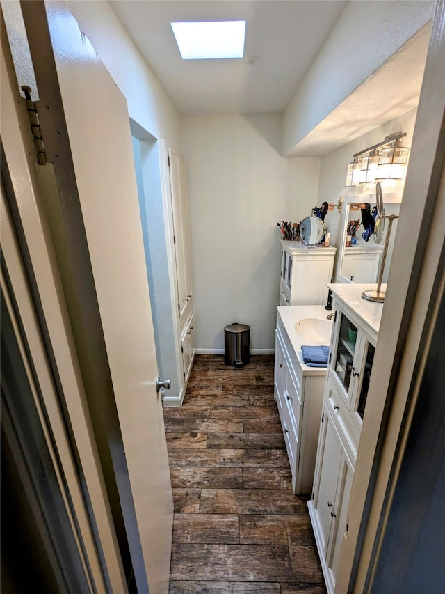 bathroom with vanity, a skylight, and hardwood / wood-style floors