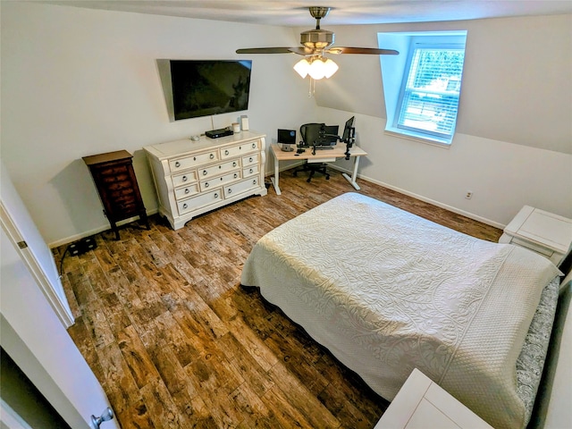 bedroom with ceiling fan, vaulted ceiling, and dark wood-type flooring