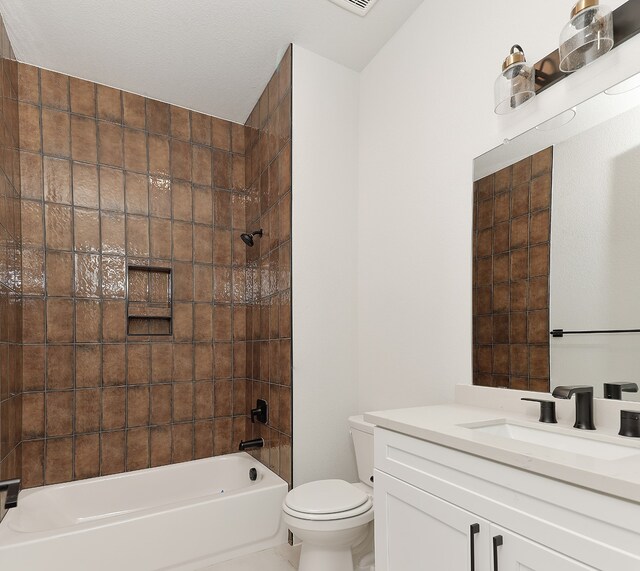 full bathroom with a textured ceiling, vanity, tiled shower / bath combo, and toilet