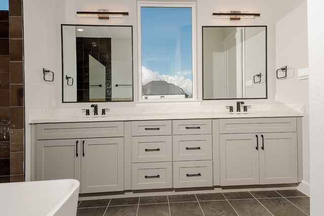 bathroom featuring a bathtub, vanity, and tile patterned flooring