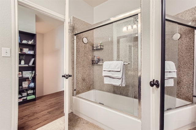 bathroom with hardwood / wood-style flooring and enclosed tub / shower combo