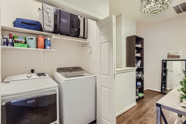 laundry area featuring dark hardwood / wood-style flooring, washer and dryer, and a chandelier