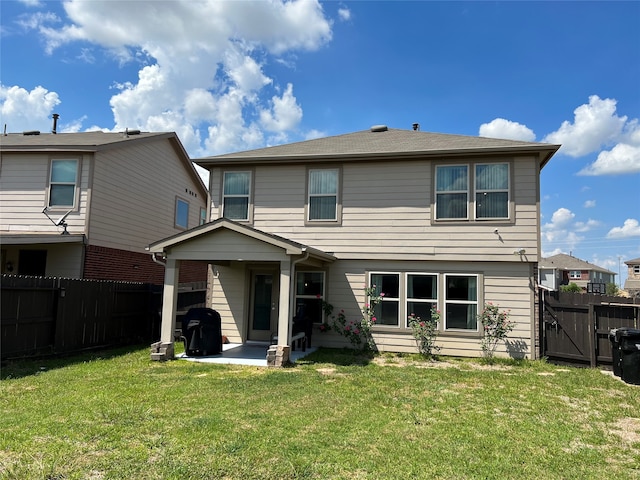 rear view of property featuring a patio and a yard