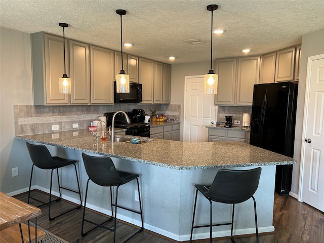 kitchen with hanging light fixtures, backsplash, kitchen peninsula, dark hardwood / wood-style flooring, and black appliances