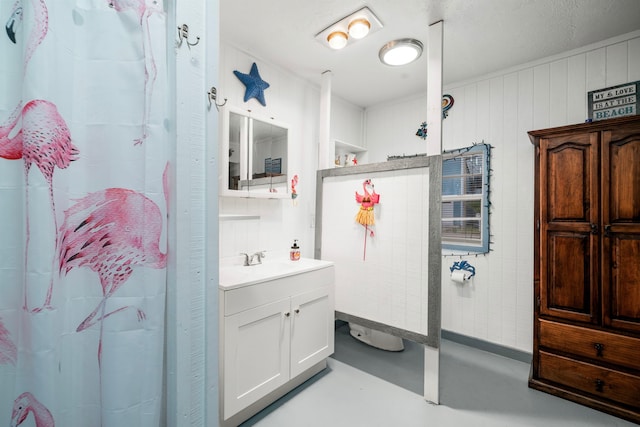 bathroom with concrete flooring, vanity, wood walls, and curtained shower