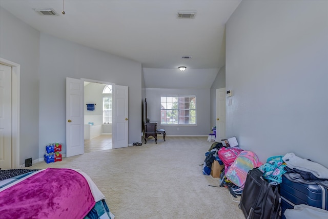 carpeted bedroom with connected bathroom and vaulted ceiling