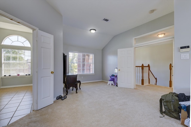 sitting room with vaulted ceiling and light tile patterned floors