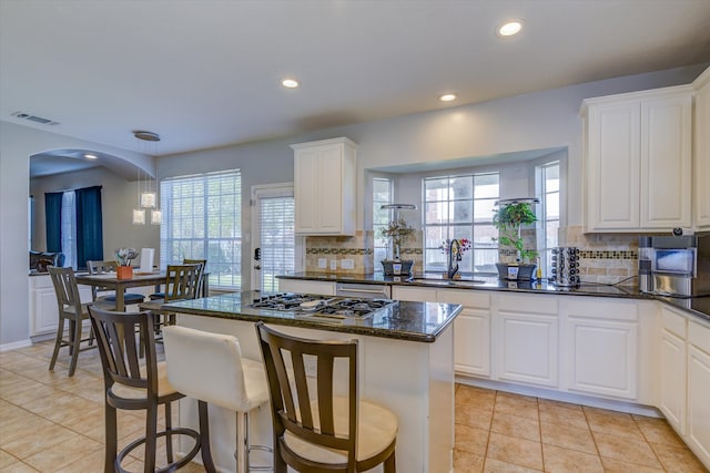 kitchen featuring appliances with stainless steel finishes, white cabinetry, tasteful backsplash, and a wealth of natural light