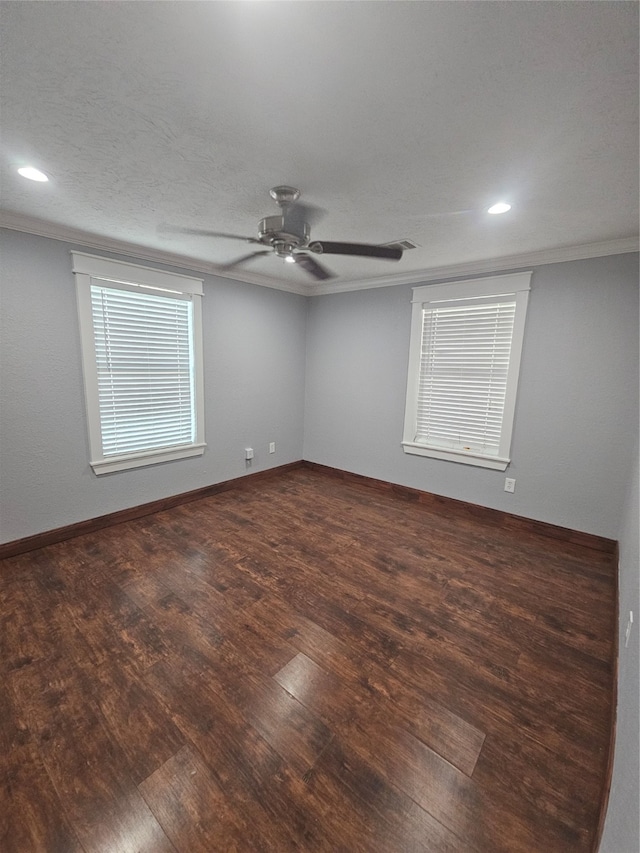 spare room with ceiling fan, crown molding, and dark wood-type flooring