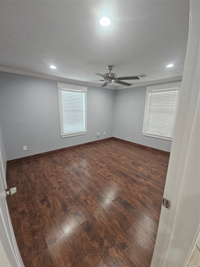 unfurnished room featuring ornamental molding, ceiling fan, and dark wood-type flooring