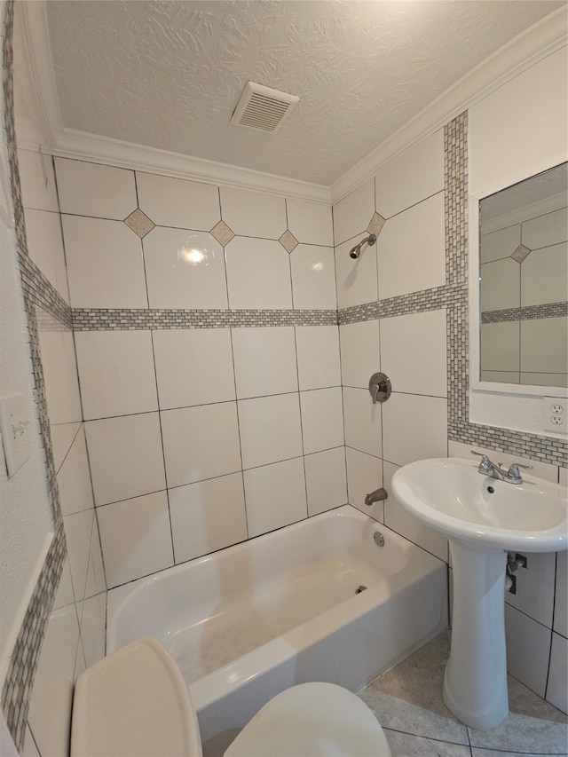 bathroom featuring tile walls, a textured ceiling, crown molding, tiled shower / bath, and toilet